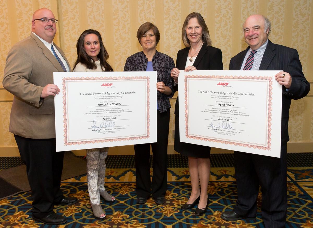 Staff holding AARP Network of Age-Friendly Communities certificates